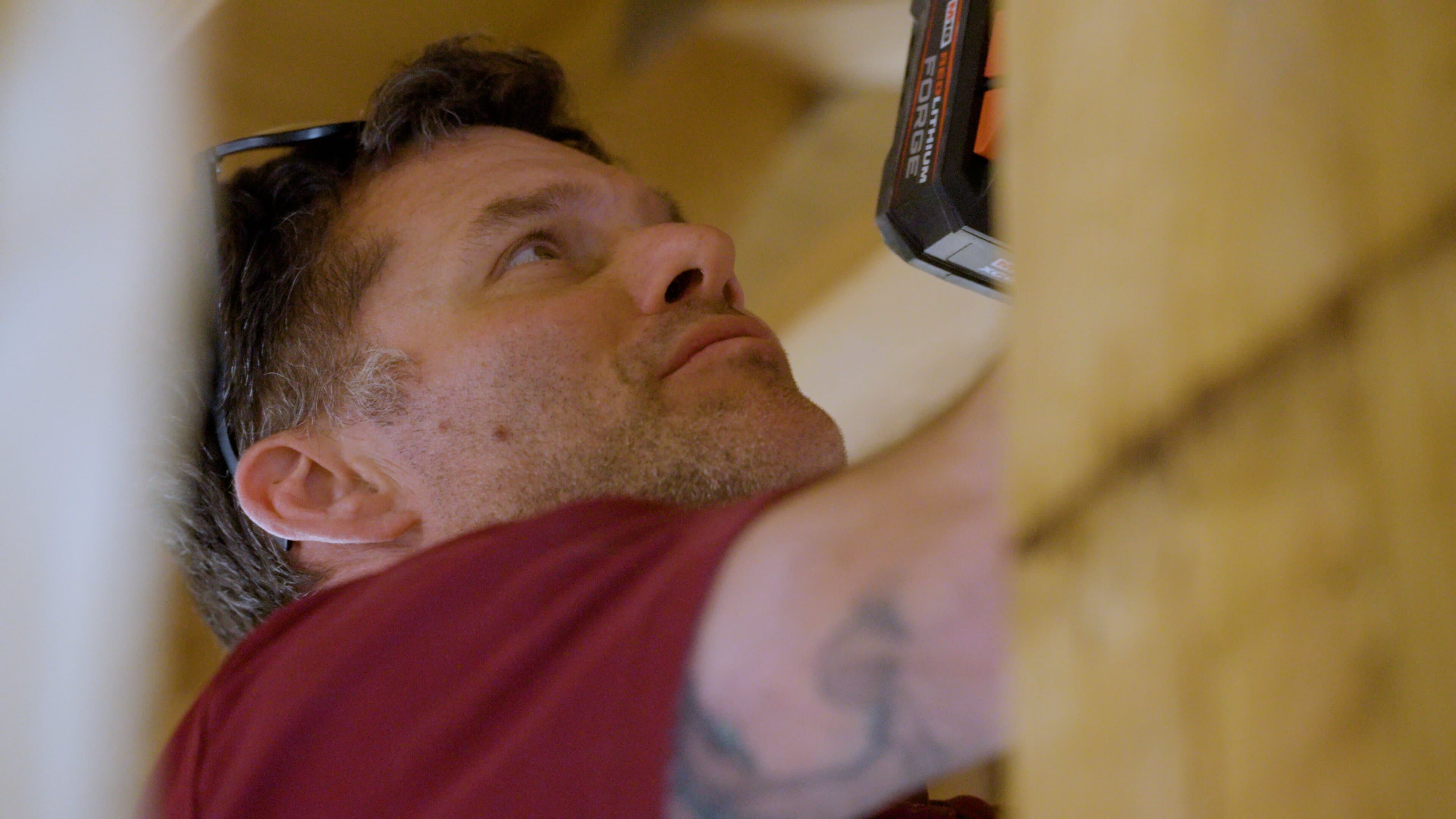 Touchstone Electric technician installing a ceiling fan