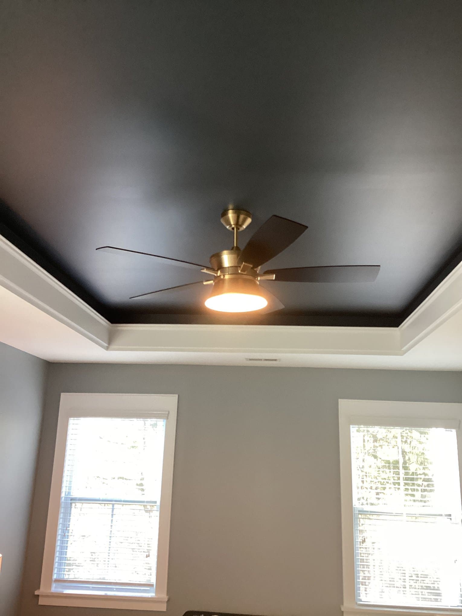 Electrician testing completed ceiling fan installation work
