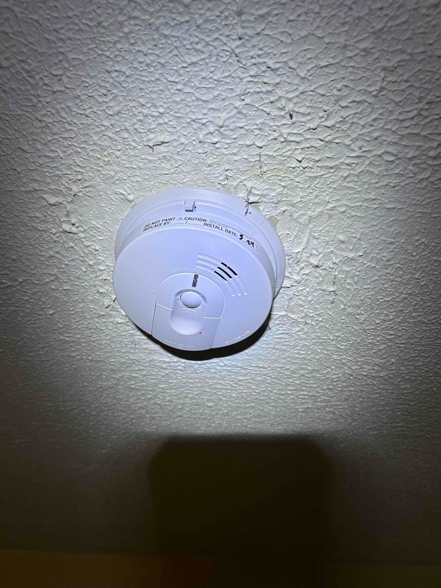 Electrician testing completed smoke & co detector installation work