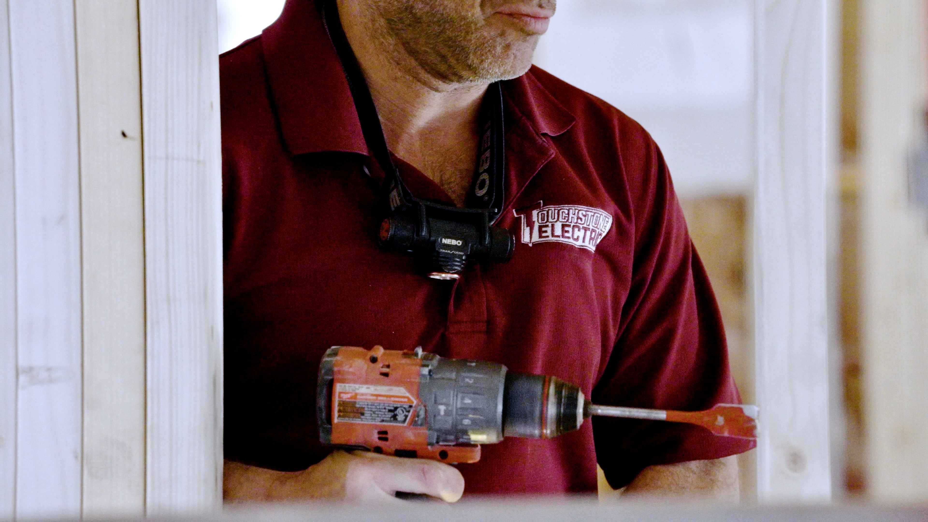Touchstone Electric drilling studs for wiring during an Oak Grove electrical project