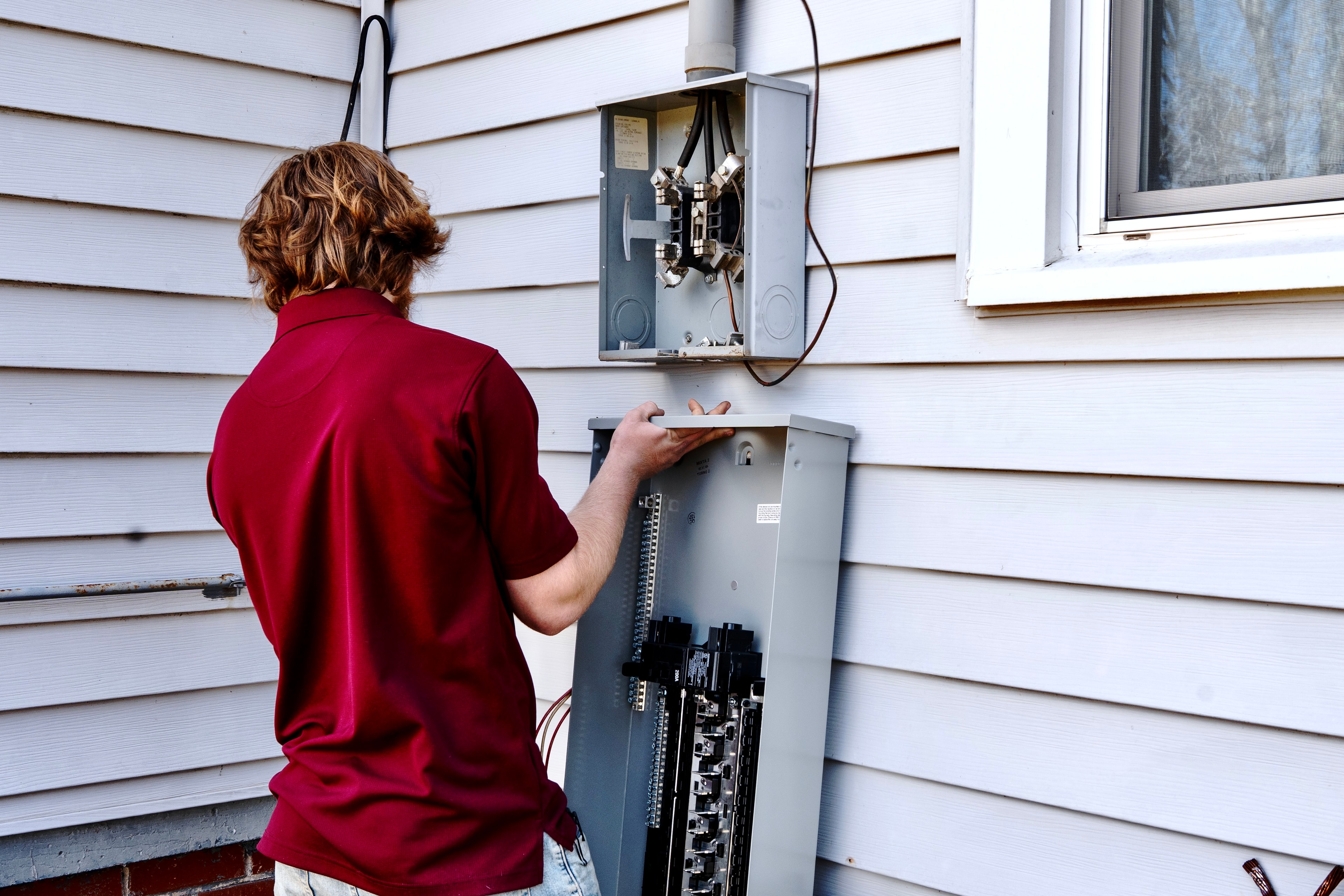 Touchstone Electric electrician inspecting and installing a residential service panel